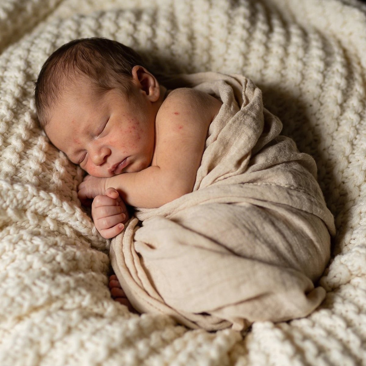 Schlafendes Neugeborenes in einer künstlerischen eingerollten Pose, fotografiert zwischen dem 5. und 15. Lebenstag